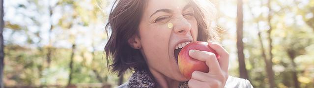woman biting eating an apple to prevent cavities