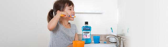 Child brushing teeth and using Listerine mouthwash